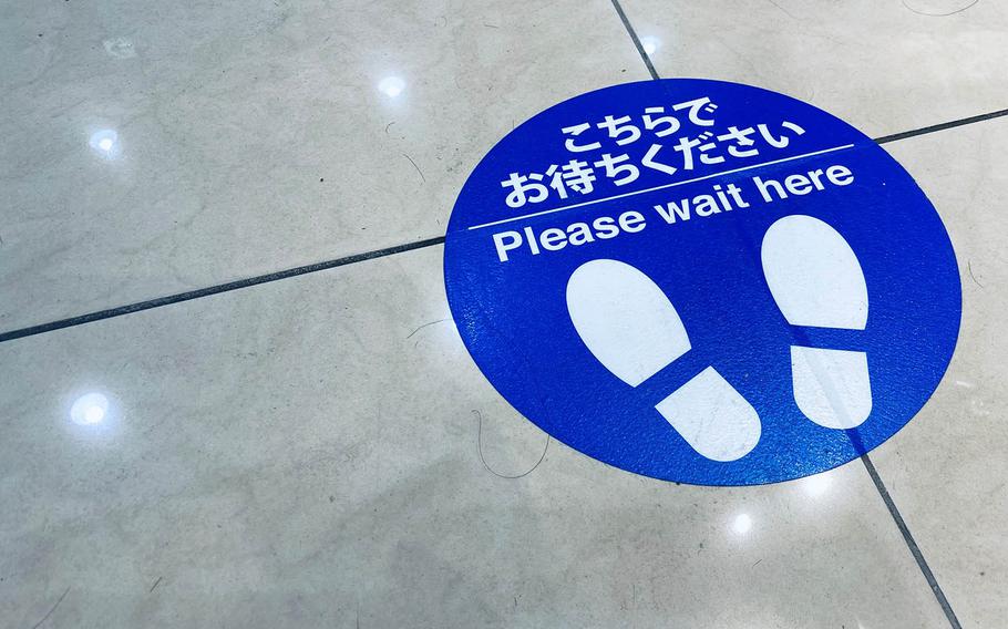 A floor decal reminds patrons to practice social distancing at a shopping mall in western Tokyo, Sunday, Nov. 8, 2020.