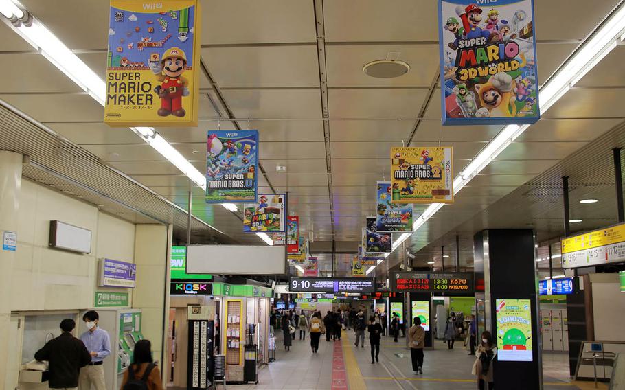 An oversized box-art exhibit chronicles the history of the Super Mario Bros. video game franchise at Shinjuku Station in Tokyo, Nov. 4, 2020.