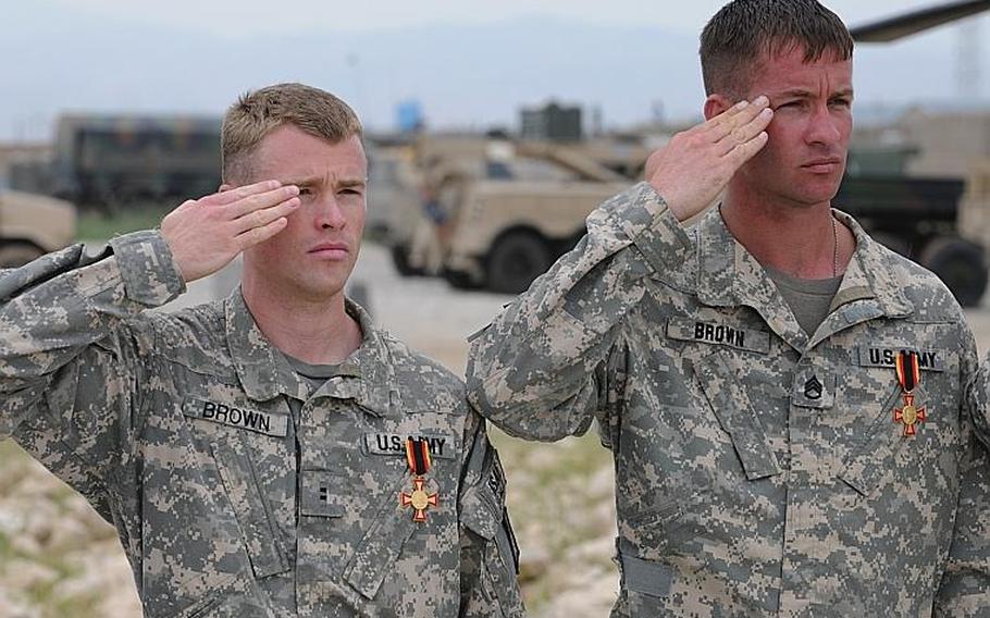 Chief Warrant Officer 3 Jason Brown (left) and Staff Sgt. Travis Brown, of 5th Battalion, 158th Aviation Regiment, based Katterbach, Germany, salute during the national anthem on May 2 after receiving Germany's Gold Cross.