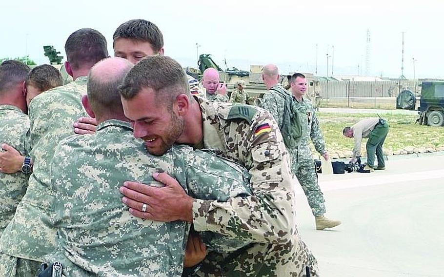 A German soldier (right) hugs U.S. Army Sgt. William Ebel of 5th Battalion, 158th Aviation Regiment on May 12 after Ebel received Germany's Gold Cross  in Kunduz, Afghanistan.