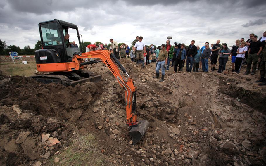 Searchers use a backhoe and hand tools to dig through soil and debris for the wreckage of a British Lancaster bomber and the remains of five of its crewmembers. Germany's Working Group for the Missing, which works to locate and recover those who died in plane crashes during World War II.