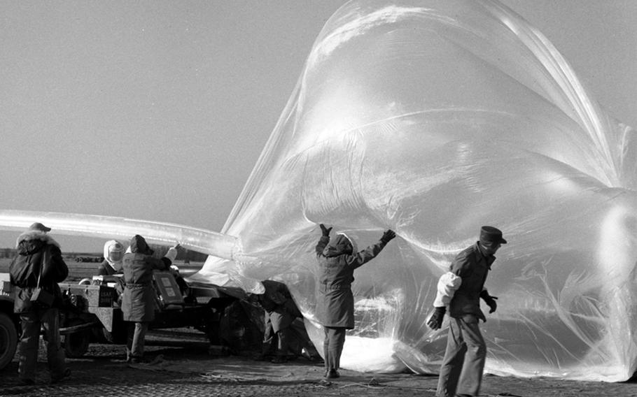 Crewmen wearing asbestos suits because of the presence of hydrogen prepare for the launch of a weather balloon at Giebelstadt, Germany, in 1956.