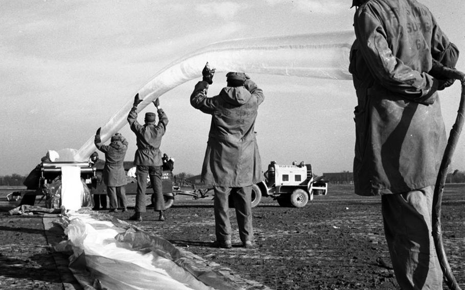 Crewmen prepare the intake valve of a weather balloon before launch at Giebelstadt, Germany, in 1956.