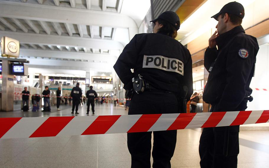 Police officers stand near the cordoned off spot where a French soldier was stabbed in the throat in the busy commercial district of La Defense, outside Paris, on Saturday May 25, 2013.