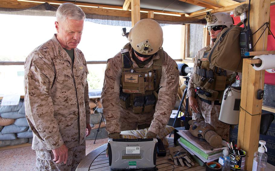 Gen. James F. Amos, commandant of the Marine Corps, reviews equipment with a Marine during a visit to the U.S. Embassy compound in Tripoli, Libya, on June 16, 2013. 