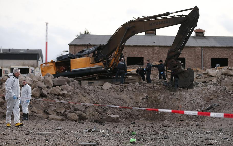 Police forces examine the scene of a World War II bomb explosion during construction works of a digger in Euskirchen, Germany, on Friday, Jan. 3, 2014. Police say one person was killed and several others were injured. 
