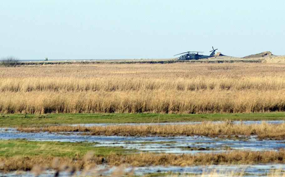 A helicopter sits near the crash site of an HH-60G Pave Hawk near Salthouse, England, on Wednesday, Jan. 8, 2013. The crash on Tuesday evening killed four airmen from RAF Lakenheath, England. Norfolk police reported two helicopters were training when the crash happened, and the second landed to assist.