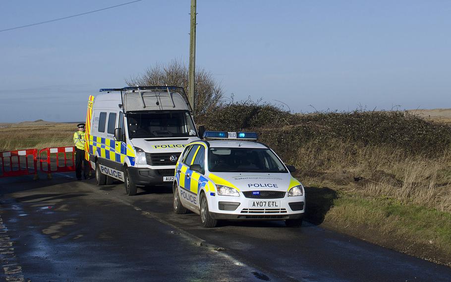 British police cordon off a road on Wednesday, Jan. 8, 2014, near the site of an HH-60G Pave Hawk helicopter crash near Salthouse, England. Four airmen from RAF Lakenheath, England, were killed in the crash on Tuesday. The crash occurred on a nature preserve, and police are restricting walking and bird watching in the area.