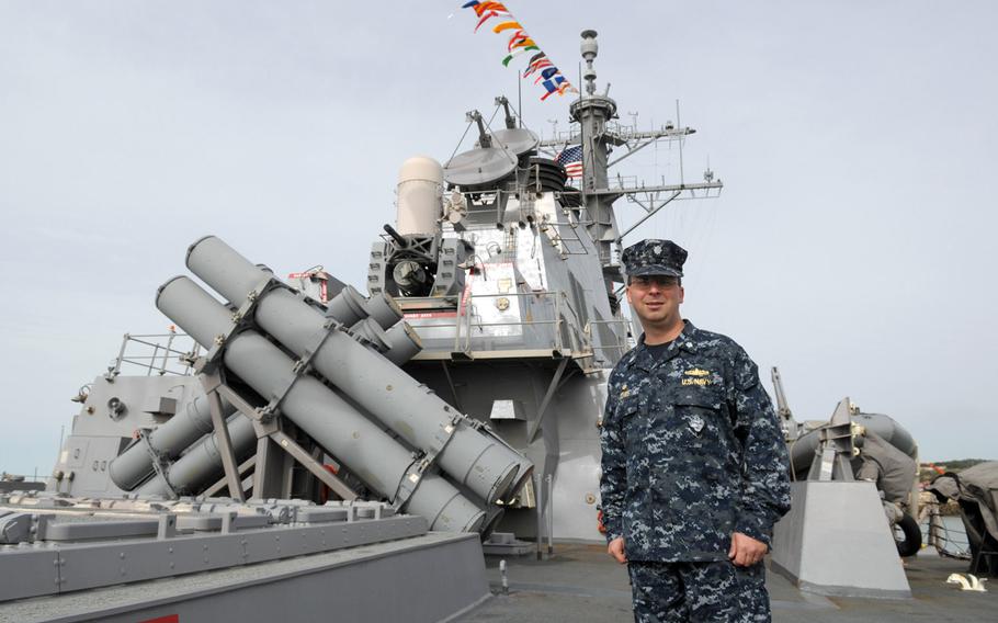 Cmdr. Scott A. Jones, commanding officer of the USS Donald Cook, stands by the aft hatches for the vertical launch system on the Arleigh Burke-class guided missile destroyer. The Cook arrived at its new home station in Rota, Spain, last week and is slated to make its first ballistic missile defense patrol in the coming month.  