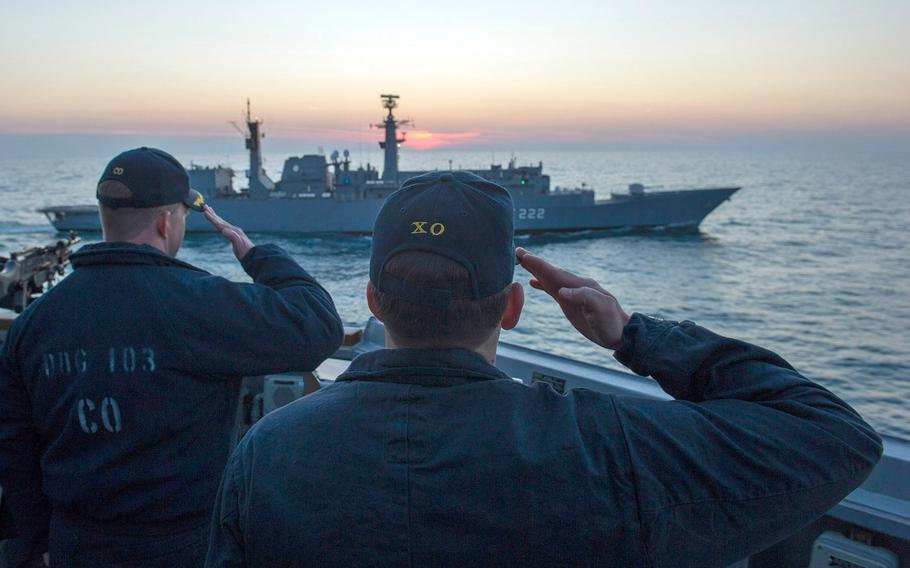 U.S. Navy Cmdr. Andrew Biehn, the commanding officer of the USS Truxtun, and Cmdr. Andrew Bates, the guided missile destroyer's executive officer, salute the Romanian frigate ROS Regina Maria aboard the Truxtun in the Black Sea on March 12, 2014. The Truxtun departed the Black Sea on March 21, 2014, following exercises with the Bulgarian and Romanian navies.