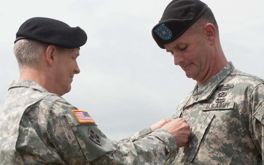 Maj. Gen. Walter Piatt, the outgoing commander for the 7th Army Joint Multinational Training Command, is frocked by Lt. Gen. Donald Campbell, the commanding general of U.S. Army Europe and the 7th U.S. Army during a ceremony held at Grafenwoehr, Germany, July 21, 2014. 