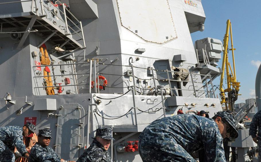 Crew members aboard the USS Oscar Austin work the mooring lines as the ship pulls into Riga, Latvia, on June 28, 2014. The guided missile destroyer's deployment to the Baltic coast is the first by a Navy warship since Russia's annexation of Crimea. 