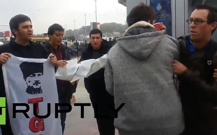 In a scene from a video posted online by the Youth Association of Turkey, a man reported to be a U.S. servicemember, at right, is roughed up by protesters.