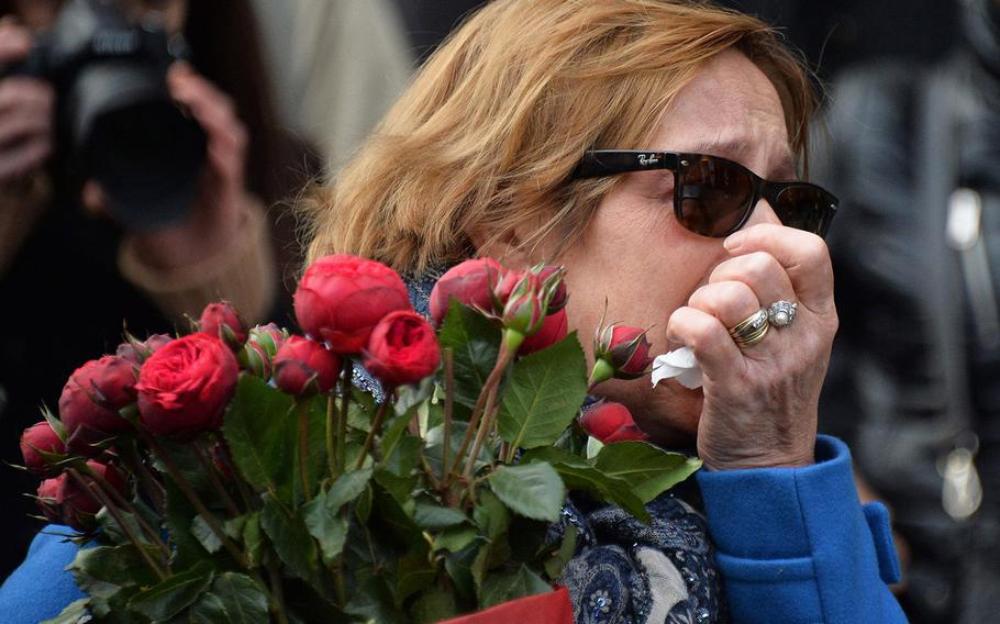 A mourner brings flowers to the scene where gunmen attacked the Paris office of French satirical magazine Charlie Hebdo on Jan. 7, 2015 in Paris, France,