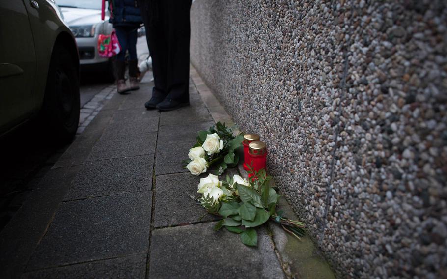 The family of Petty Officer 2nd Class Dmitry Chepusov placed candles and flowers on the sidewalk outside the apartment building in Kaiserslautern, Germany, where the sailor was killed in December 2013.