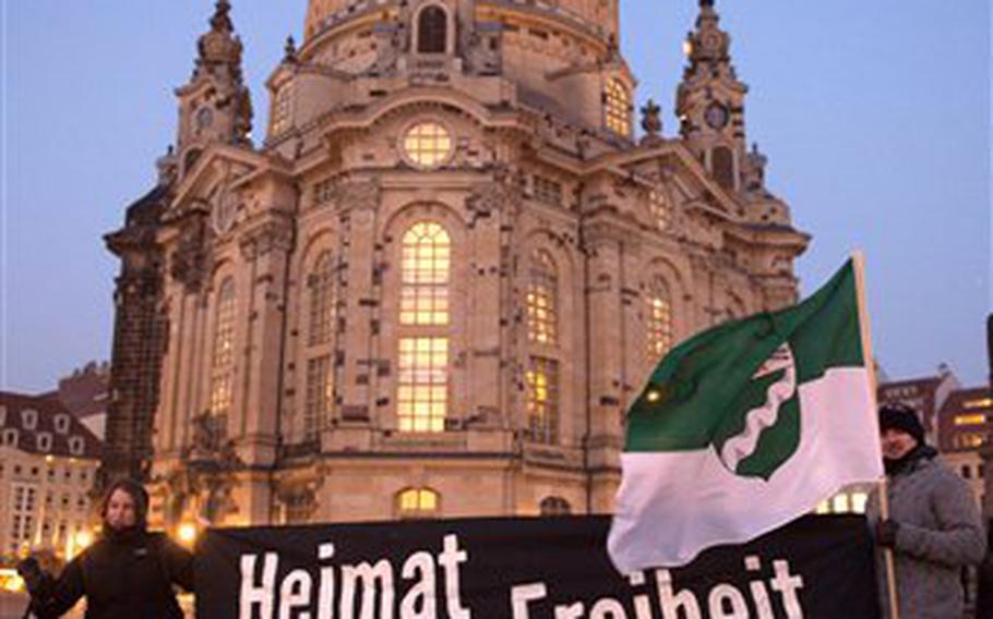 Members of the anti-Islamic Patriotic Europeans against the Islamization of the West (PEDIGA) alliance gather in front of the Church of our Lady with a banner saying "Homeland, Freedom, Tradition" in Dresden, Germany, on Monday, Feb. 16, 2015. 