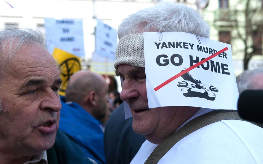 A protester in Prague's Wenceslas Square expresses his opposition to a convoy of American troops through the Czech Republic, Saturday, March 28, 2014. The crossing will mark the end of the U.S. Army's 2nd Cavalry Regiment Dragoon Ride, an 11-day trek of roughly 120 vehicles across eastern Europe designed as a show of force in response to Russia's military aggression in Ukraine.