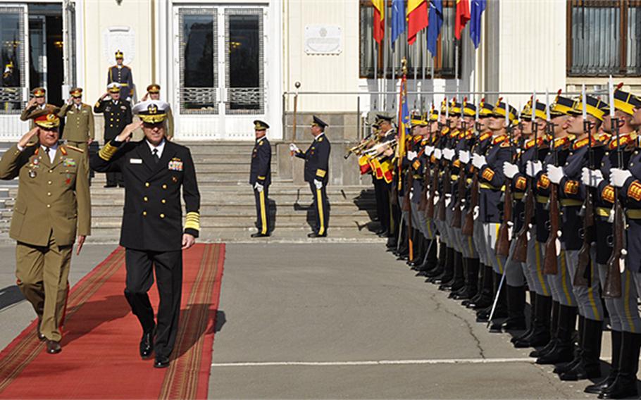 Allied Joint Force Command Naples commander, U.S. Navy Adm. Mark Ferguson III, second from left, salutes as he passes an honor guard during his visit to Bucharest, Romania, Tuesday, May 5, 2015. NATO for the first time will deploy a command post to Romania to take part in a June exercise aimed at testing the alliance's crisis-response capabilities.
