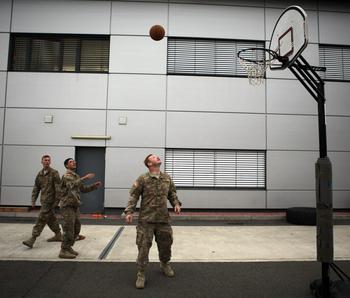 Pfc. James Borgerding, left, Spc. Luis Aguilar and Spc. Cody Hampton, all of Company C, 3rd Combined Arms Battalion, 69th Armor Regiment, play basketball Saturday, June 20, 2015, while waiting to load an M1A2 Abrams tank onto a C-17 transport plane at Ramstein Air Base in Germany.

