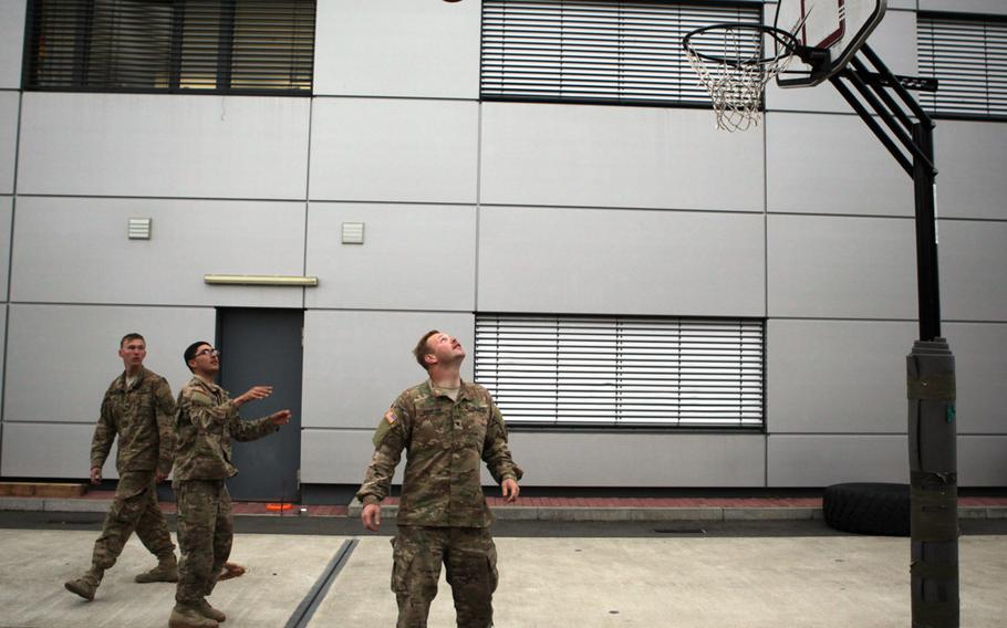 Pfc. James Borgerding, left, Spc. Luis Aguilar and Spc. Cody Hampton, all of Company C, 3rd Combined Arms Battalion, 69th Armor Regiment, play basketball Saturday, June 20, 2015, while waiting to load an M1A2 Abrams tank onto a C-17 transport plane at Ramstein Air Base in Germany.

