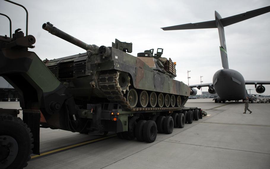 Soldiers and airmen prepare to load an M1A2 Abrams tank onto a C-17 transport plane at Ramstein Air Base in Germany, on Saturday, June 20, 2015.


