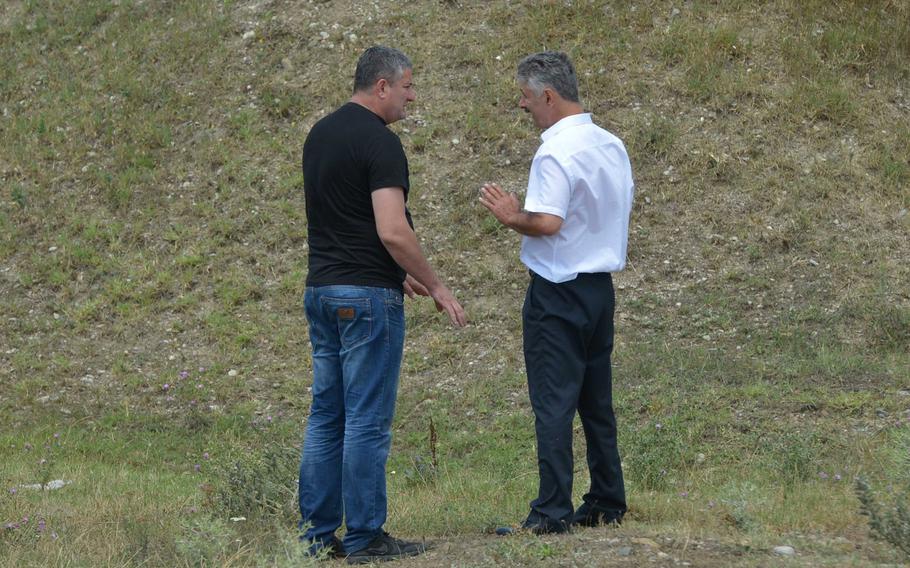 Davit Baidauri of the Georgian police, left, and Robert Gasaev,who identified himself as deputy chief of the South Ossetia border control, discuss the situation after Gasaev took down a Georgian flag that he said was on South Ossetian territory, near Khurvaleti, Georgia, Thursday, July 16, 2015.