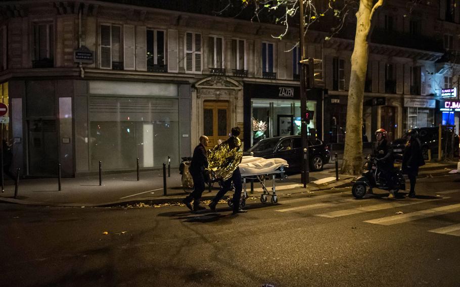 A victim is being evacuated from the Bataclan concert hall after a shooting in Paris, France, Saturday, Nov. 14, 2015. Well over 100 people were killed in Paris on Friday night in a series of shooting, explosions. French President Francois Hollande declared a state of emergency and announced that he was closing the country's borders.