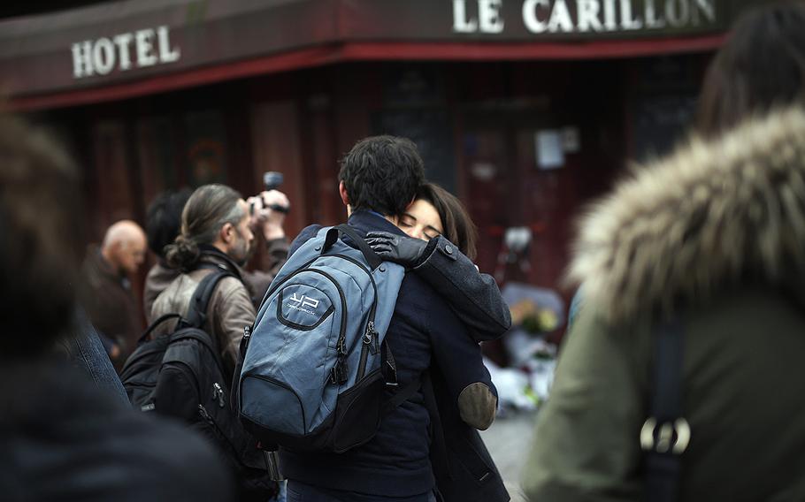 People react in front of   the Carillon cafe and the Petit Cambodge restaurant  in Paris Saturday Nov. 14, 2015, a day after attacks in Paris left at least 127 dead.