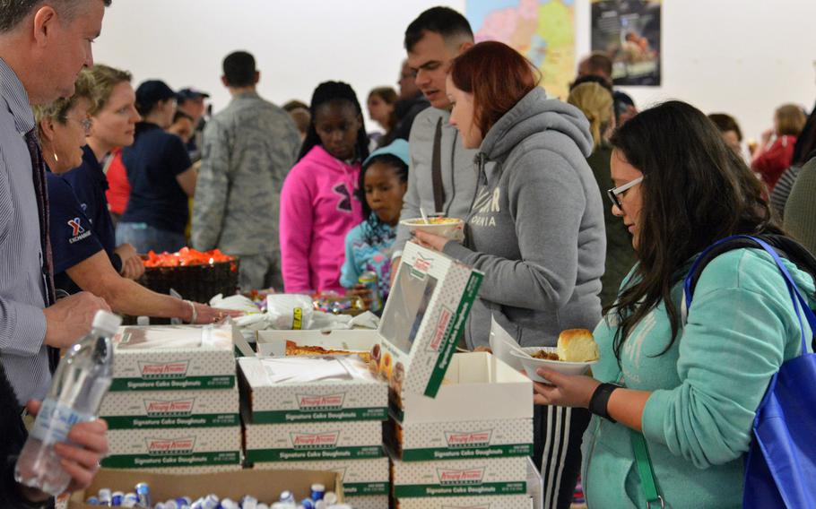 Dependents arriving from Incirlik Air Base, Turkey, take food offered by Army and Air Force Exchange Service and the USO after arriving at Ramstein Air Base, Germany, March 31, 2016.

