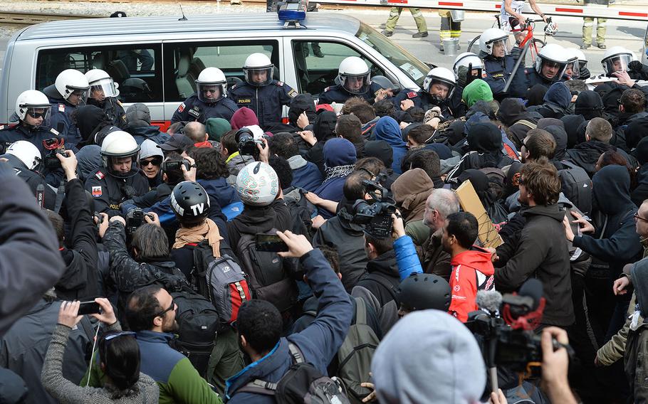 Police  try to stop protesters who demonstrate against new borders, on their way in the Italian village of Brenner on the Italian-Austrian border, Sunday, April 3, 2016.  Austria's defense minister said his country will deploy soldiers at a key Alpine pass to stop migrants arriving from Italy. 