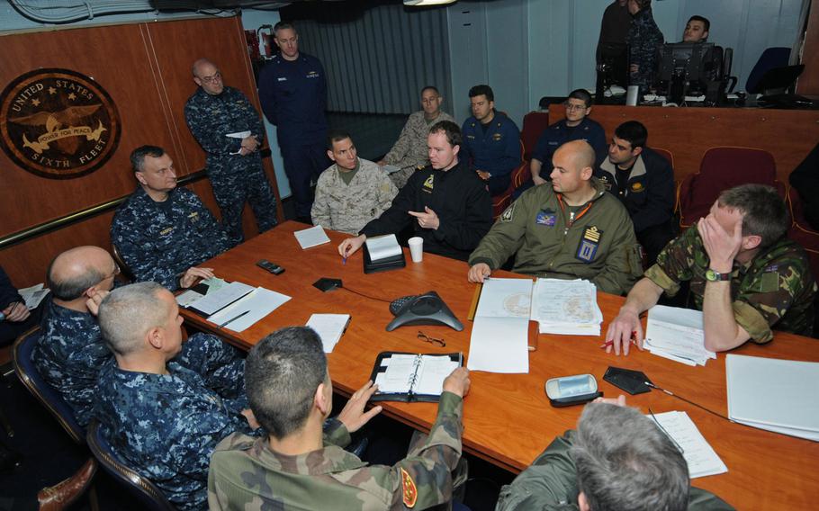 Liaison officers from coalition countries meet with Joint Task Force Odyssey Dawn staff members aboard the USS Mount Whitney in 2011 to discuss operations against the Libyan regime of Moammar Gaddafi. 

