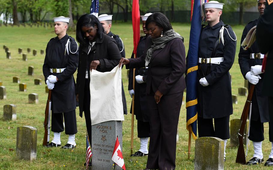 District of Columbia Executive Director of the Mayor's Office of Veterans Affairs Tammi Lambert, left, and Director of the Department of Behavioral Health Tanya A. Royster, right, unveil the headstone of Medal of Honor recipient Joseph B. Noil during a ceremony Friday, April 29, 2016, at St. Elizabeths Hospital Cemetery in Washington, D.C. Noil received the Medal of Honor while serving on USS Powhatan, but his headstone did not recognize his award because of a misprint on his death certificate.