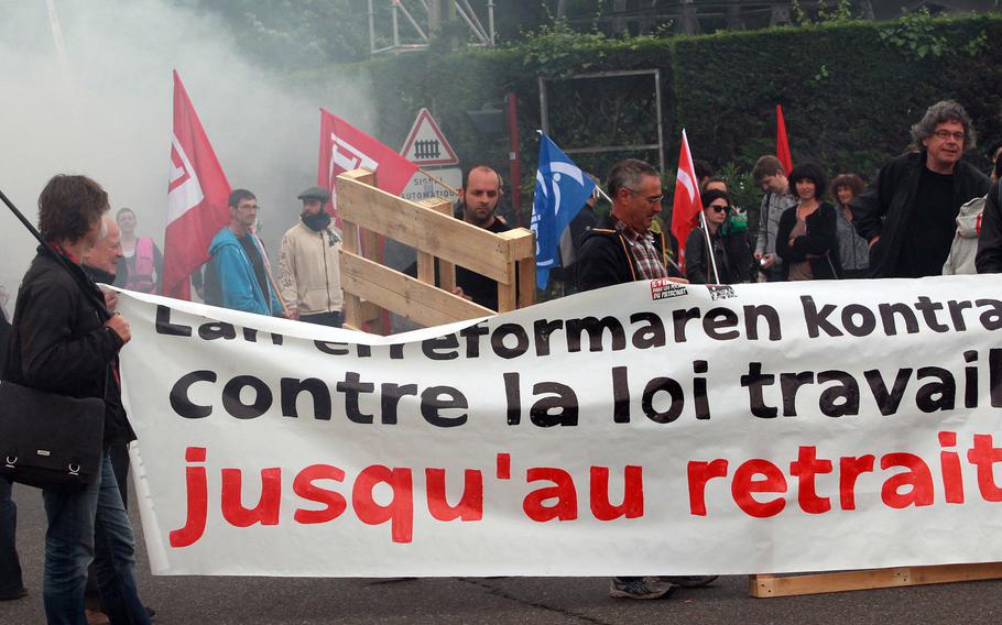 Union activists block the entrance of the industrial area in Boucau, near Bayonne, southwestern France, on a day of nationwide strikes and protests over a labor reform, Thursday, May 26, 2016. France's government vowed "no retreat" from planned labor law reforms Thursday even as unions called for wider strikes that have choked off fuel supplies and created chaos on highways blocked by barricades of burning tires.