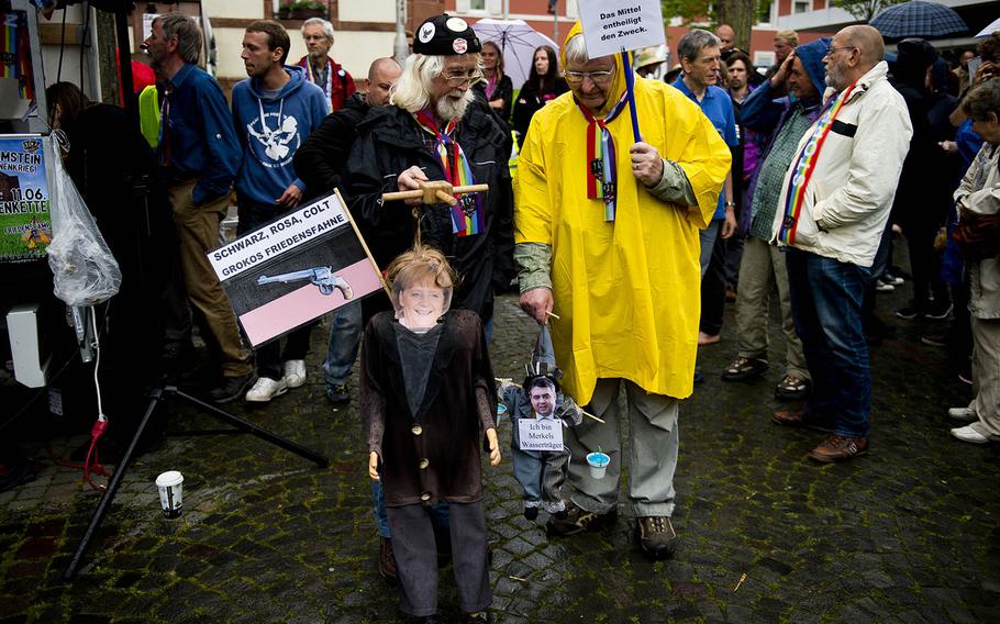 Protesters carrying puppets and signs listen to a rap group in Ramstein-Miesenbach, Germany, on Saturday, June 11, 2016. They were protesting against Ramstein Air Base's alleged role in U.S. drone operations.

 
