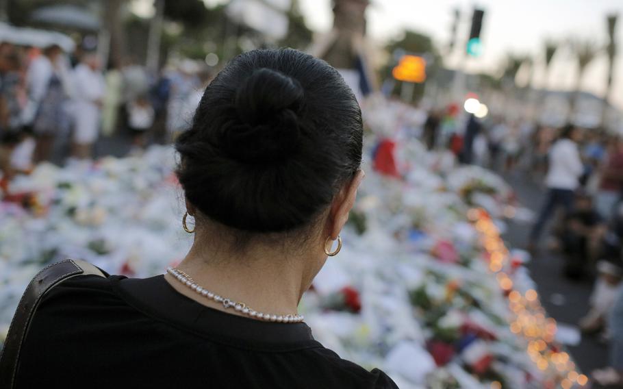 A woman pays tribute to the victims of a deadly truck attack at the site of the attack on the famed Boulevard des Anglais in Nice southern France, Saturday, July 16, 2016.