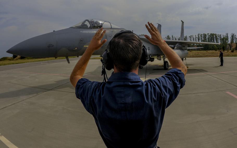 California Air National Guard Staff Sgt. Zechery Blackburn, a 194th Expeditionary Fighter Squadron crew chief, signals to the pilot of an F-15C Eagle fighter aircraft on the flight line at Graf Ignatievo, Bulgaria, Sept. 8, 2016. Four of the squadron's F-15Cs are conducting joint NATO air policing missions with the Bulgarian air force.