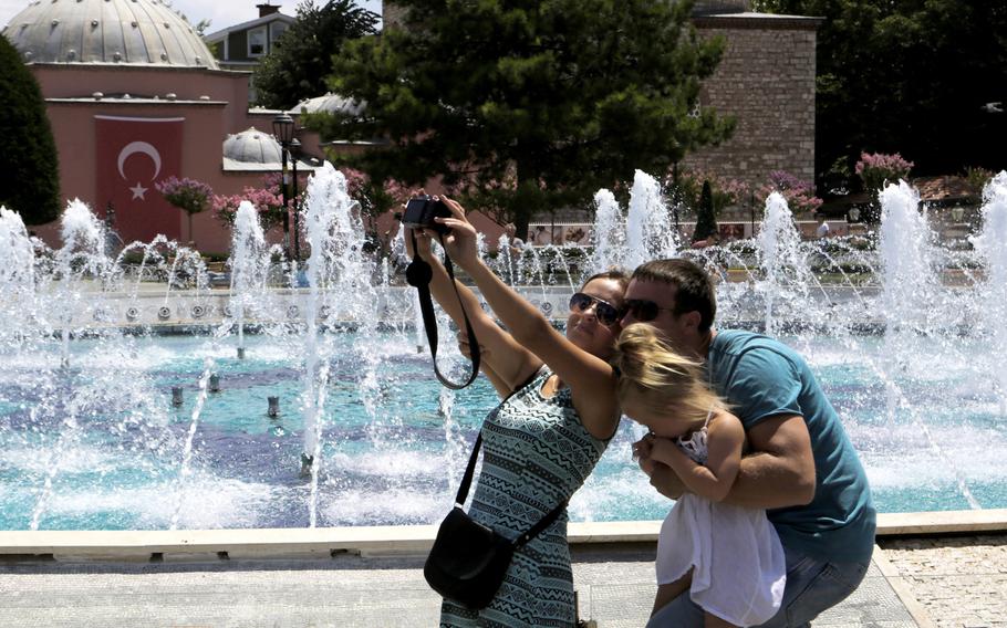 In this Tuesday, July 26, 2016 file photo,  tourists take a selfie at the Byzantine-era Hagia Sophia, in the historic Sultanahmet district of Istanbul. 