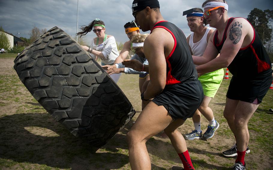 The Shady 80s, a 37th Airlift Squadron team, flip a tire during the annual Courage, Leadership, Education, Advocacy and Respect Challenge at Ramstein Air Base, Germany, on Friday, April 14, 2017.
