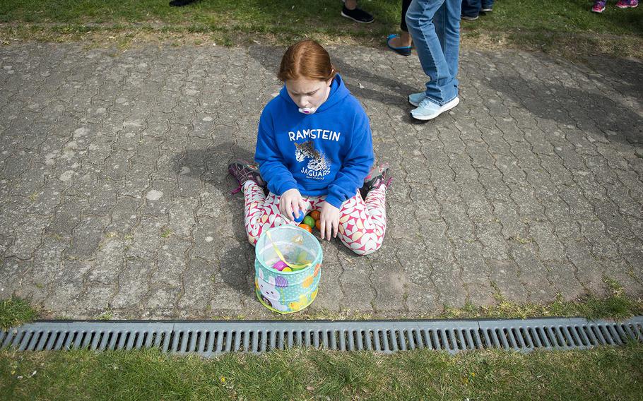 Layla Burton, daughter of Tech. Sgt. Lloyd Burton from the 603rd Air Operations Center, inspects her eggs during the annual Easter Egg Hunt at Ramstein Air Base, Germany, on Saturday, April 15, 2017.