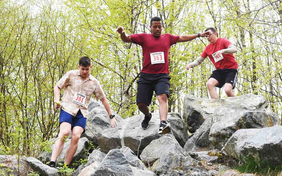 Obstacle course runners make their way over a large pile of stones during an annual run in Grafenwoehr, Germany, Saturday, April 15, 2017. 