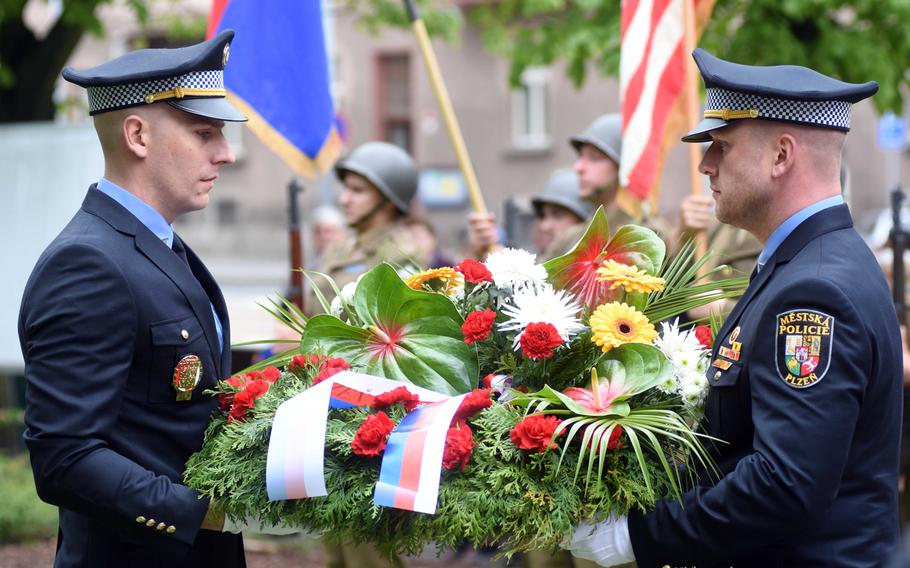 Police officers in Pilsen, Czech Republic, carry flowers to the city's monument to the American Army 2nd Infantry Division, Friday, May 5, 2017. The city of Pilsen annually celebrates the American liberation of their city in May.