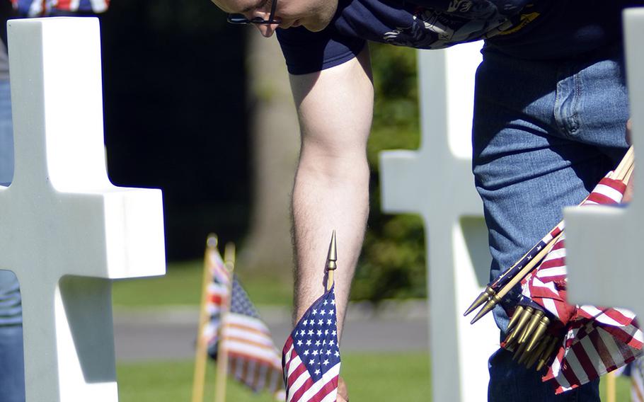 U.S. Army Sgt. Jacob Teller places an American flag among headstones at the Cambridge American Cemetery and Memorial in Cambridge, England, Friday, May 26, 2017, in preparation for this Memorial Day. This year also marks the 75th Anniversary of the "friendly invasion" of Britain by American forces during World War II.