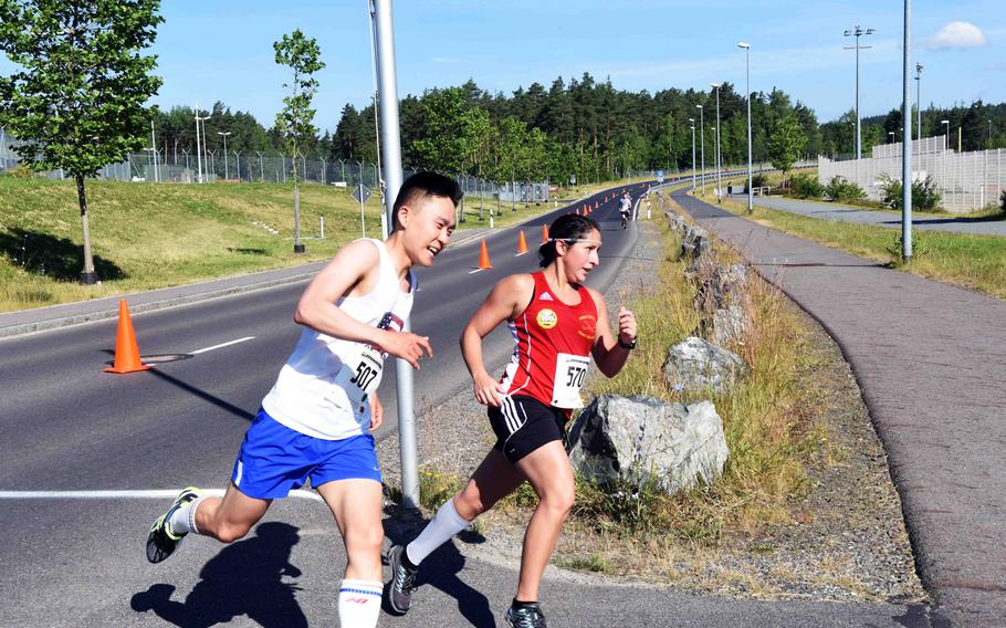 Spc. Hyungkon Son and Capt. Cheryl Ryan race to the finish line during the Army 10-miler qualification run at Grafenwoehr, Germany, Saturday, June 24, 2017. 
