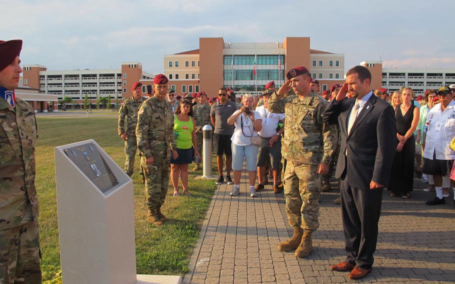Col. Greg Johnson, 173rd Airborne Brigade commander, and former Staff Sgt. Sal Giunta salute at a new memorial to the brigade's 18 Medal of Honor awardees on July 6, 2017, in Vicenza, Italy.