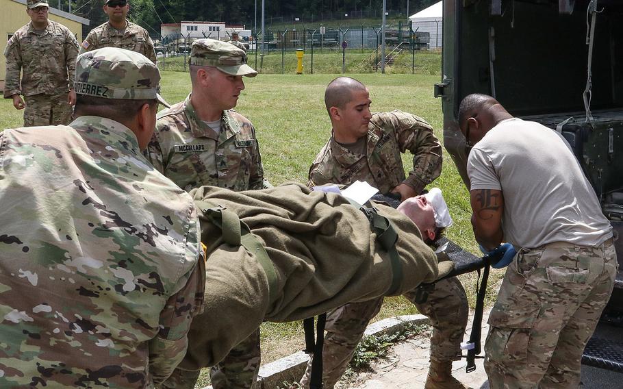 Soldiers of the 21st Combat Support Hospital out of Fort Hood, Texas, load a casualty into the back of an Army medical vehicle during a KFOR 23 mission rehearsal exercise at the Joint Multinational Readiness Center in Hohenfels, Germany, Tuesday,  July 4, 2017.