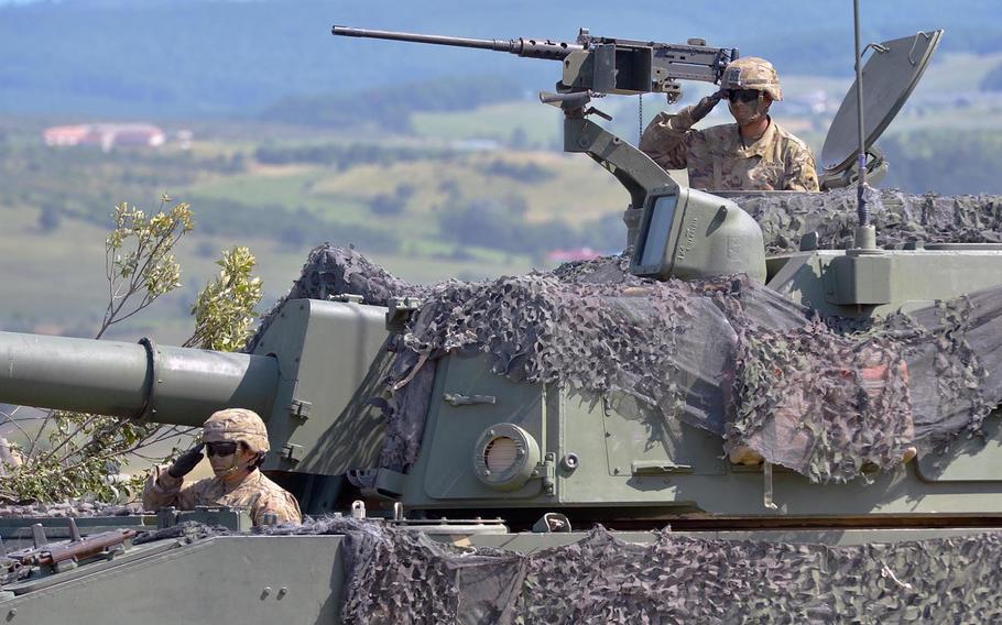 Soldier manning a M109 Paladin salute during the playing of the national anthem at the 3rd Armored Brigade Combat Team, 4th Infantry Division's change of command ceremony at the Center for Joint National Training in Cincu, Romania, Saturday, July 15, 2017. Col. Michael Simmering took over the brigade from Col. Christopher Norrie.