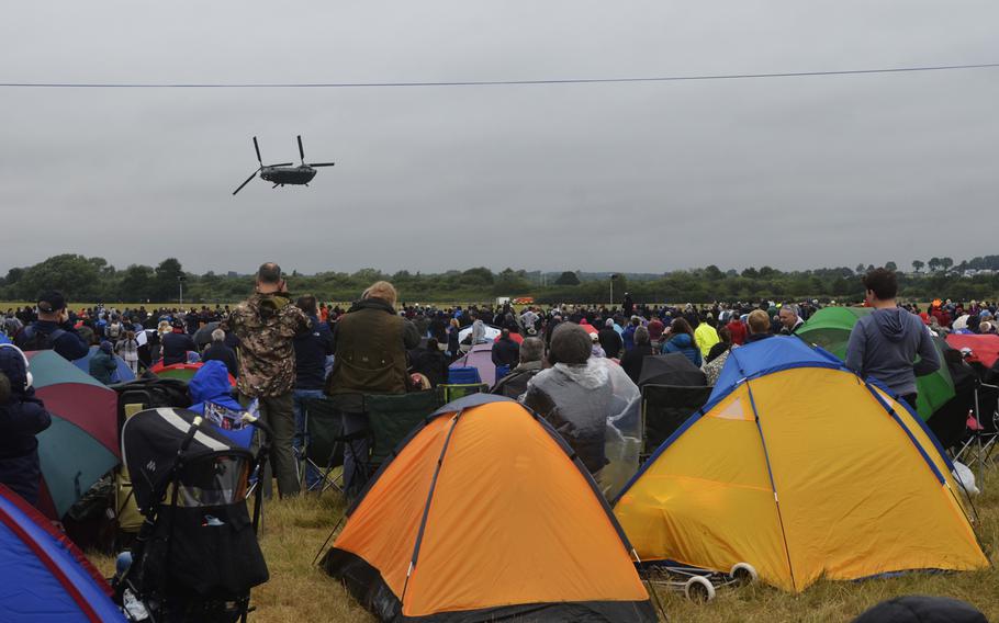 A crowd of attendees view an aerial performance of a Royal Air Force Chinook helicopter during the Royal International Air Tattoo at RAF Fairford, Saturday, July 15, 2017.