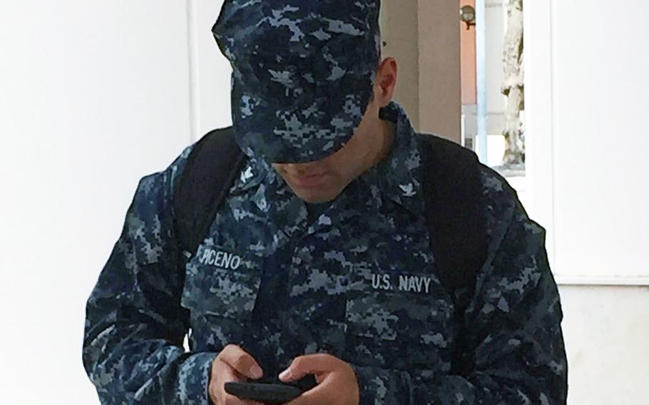 Petty Officer 3rd Class Eddie Piceno looks at his phone while he texts at U.S. Navy Base Capodichino in Naples, Italy, Tuesday, July 25, 2017. Piceno agrees with the Italian government's effort to crack down on drivers using cellphones. 