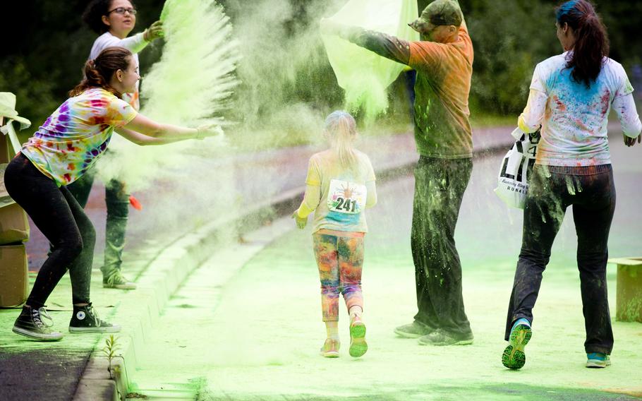 A girl makes her way through the American Forces Network Europe color station during the Color Run at Ramstein Air Base, Germany, on Saturday, Aug. 12, 2017.

