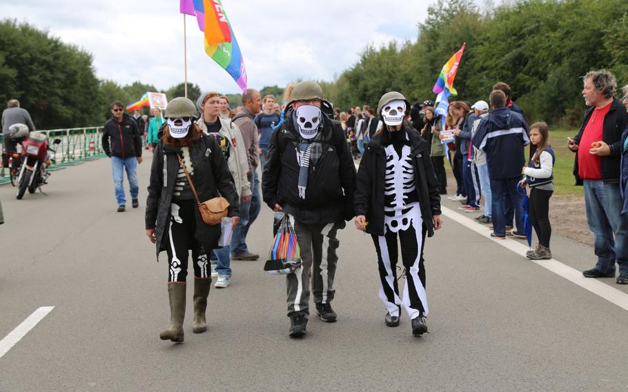 Three protesters dressed as skeletons at Ramstein Air Base in Germany march during demonstrations on Sept. 9, 2017.